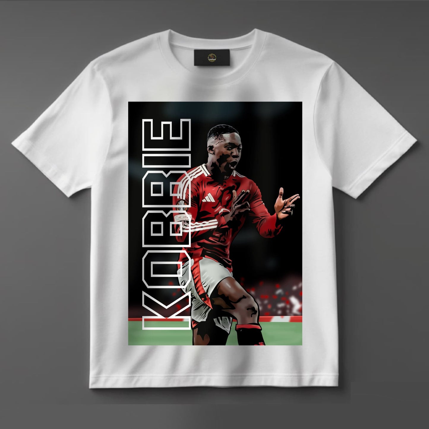 Black or white T-shirt featuring bold artwork of Kobbie Mainoo in Manchester United kit, celebrating as a Europa League hero — a powerful tribute to the young midfield star and his rising legacy.