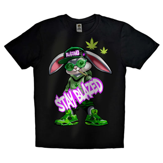 Black or white T-shirt featuring a laid-back cartoon rabbit with red eyes, puffing on a joint with smoke swirling around and the phrase ‘Stay Blazed’ — a fun, trippy design for cannabis lovers and stoner streetwear fans.