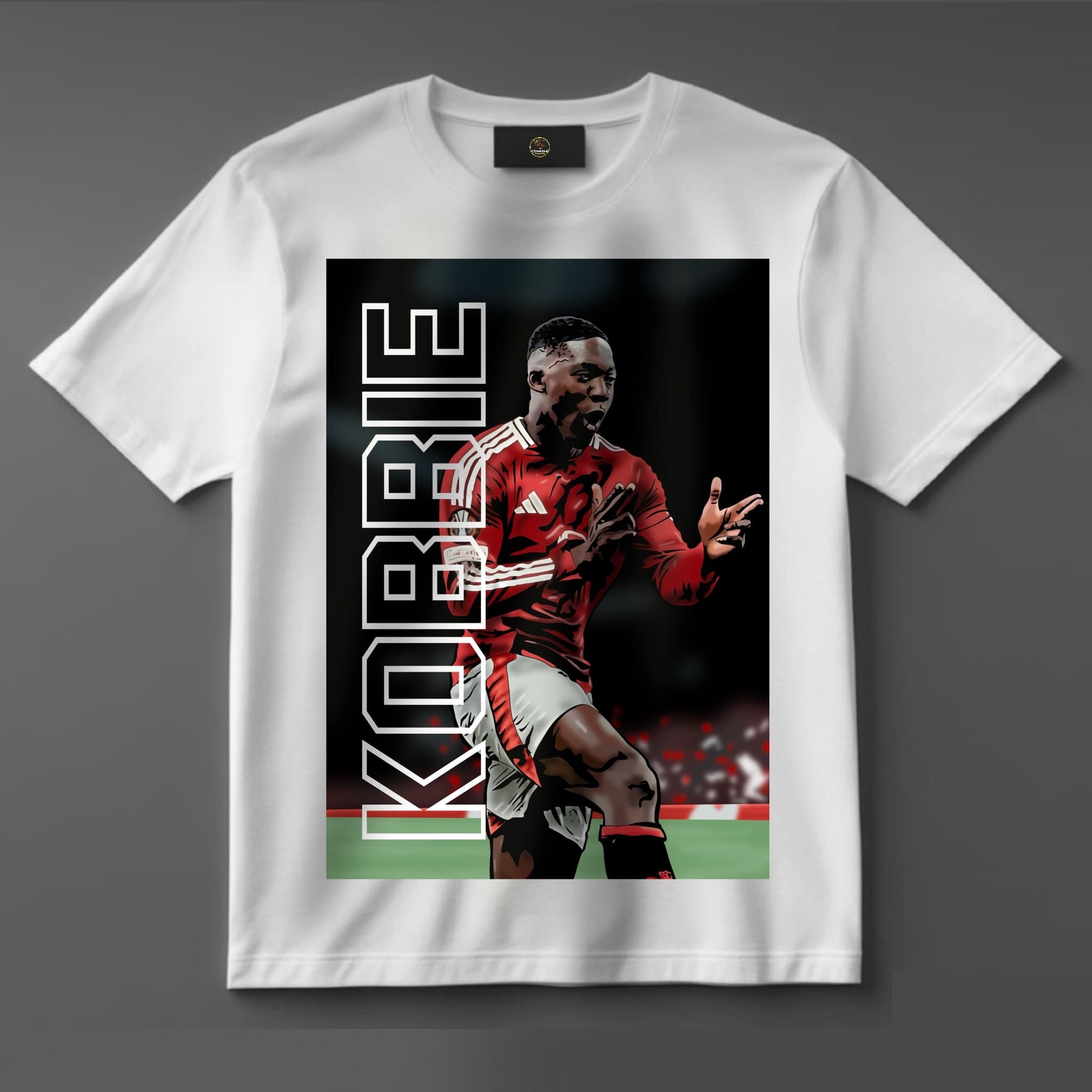Black or white T-shirt featuring bold artwork of Kobbie Mainoo in Manchester United kit, celebrating as a Europa League hero — a powerful tribute to the young midfield star and his rising legacy.